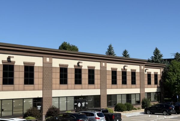 Modern two-story commercial office building with professional office suites, large parking lot, and landscaped grounds.